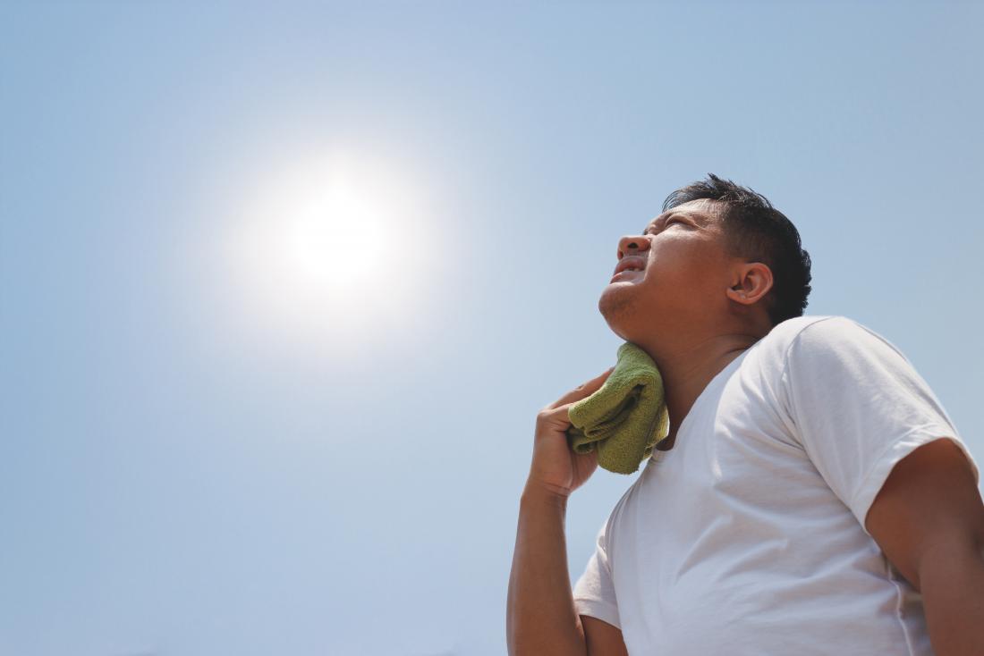 A man holding his head in the sun