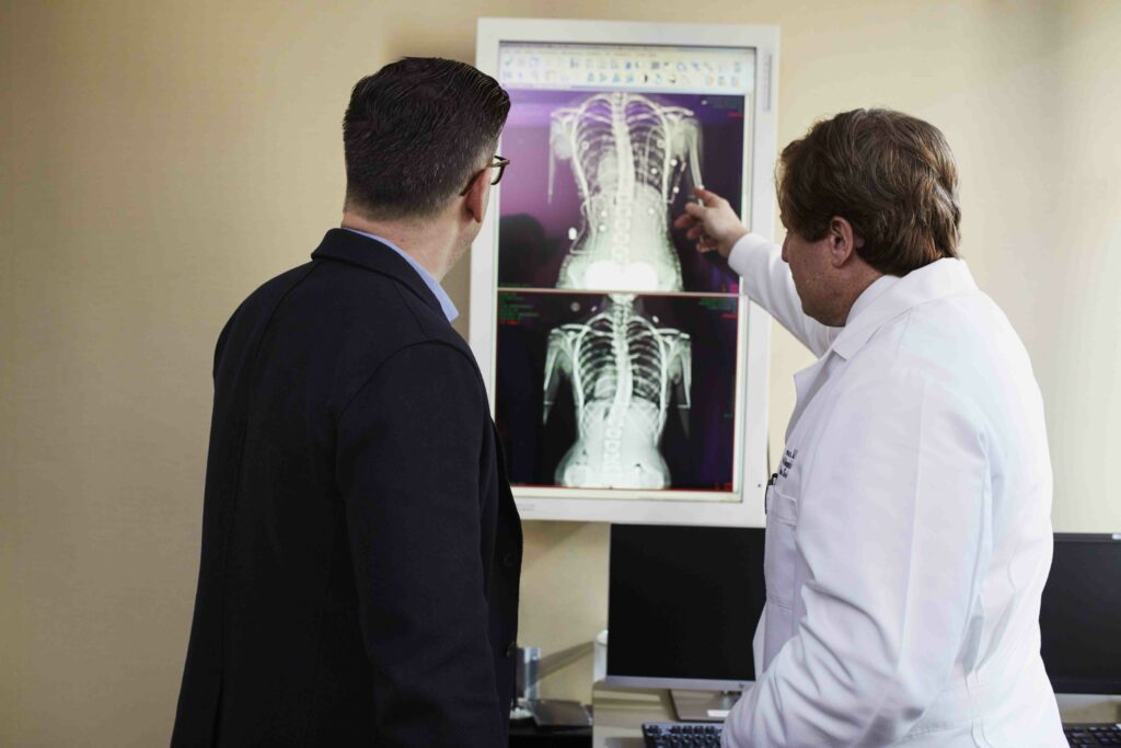 Two men looking at a picture of an x-ray.