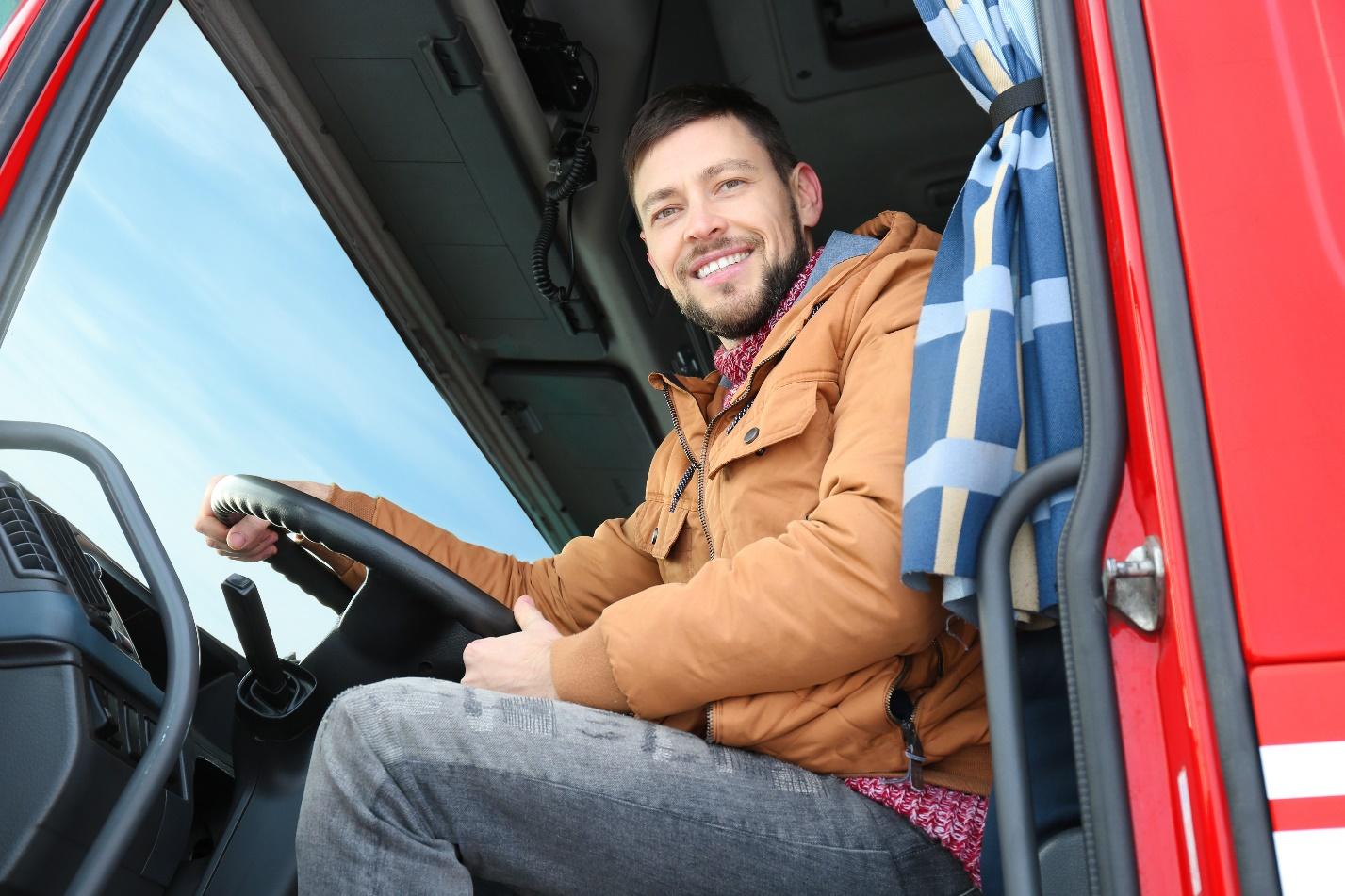 A man sitting in the driver 's seat of a truck.